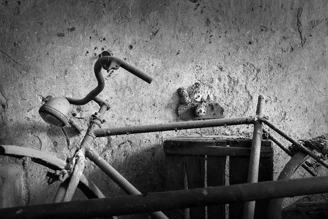 A bicycle beside a deteriorating wall.